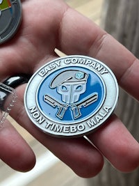 a person is holding a badge with a logo on it
